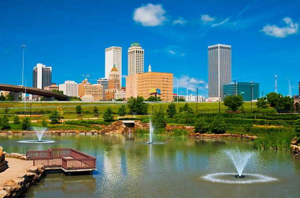 "Tulsa skyline with a park, pond, and fountains in the foreground."